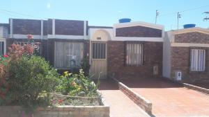 a brick house with a door and some flowers at Casa Adelita Paraíso Azul in Aquitania