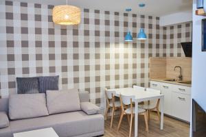 a living room with a couch and a table at Piaskowe Domki in Grzybowo +7 photos