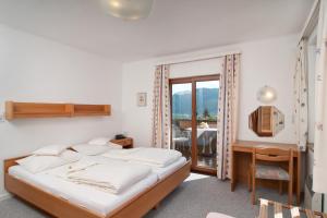賽特朵夫的住宿－蘇澤恩霍夫酒店，一间卧室配有一张床、一张书桌和一个窗户。