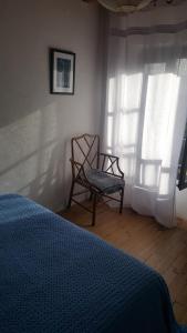1 dormitorio con 1 cama, 1 silla y 1 ventana en Joli gîte en Ariège avec vue, en Buzan