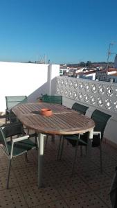 a wooden table and chairs on top of a roof at Laura y Mauro in Villanueva del Fresno