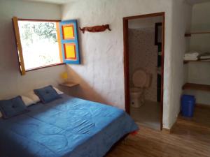 ein Schlafzimmer mit einem blauen Bett und einem Fenster in der Unterkunft Hostal Encanto La Salada in Jardin