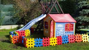 ein Spielhaus und eine Rutsche im Gras in der Unterkunft Willa Elf in Karwia