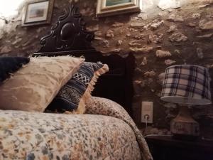 een slaapkamer met een bed en een stenen muur bij Cal Pons in Prades