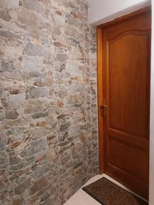 a hallway with a stone wall and a wooden door at Gáldar, habitación privada en la playa in Gáldar