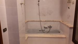 a bath tub with a shower in a bathroom at La Casetta di Nonna Anna in Palermo +16 photos