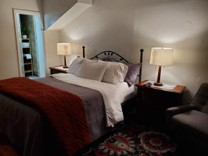 a bedroom with a bed and two lamps and a chair at Studio B on Atlantic Ave in Brooklyn