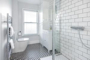 a white bathroom with a toilet and a shower at Park View Ground Floor 1 Bed Apt in Bath