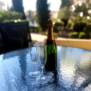 uma garrafa de champanhe e dois copos de vinho numa mesa em Owls Nest Townhouse em Pafos