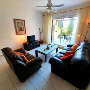 a living room with two leather couches and a table at Owls Nest Townhouse in Paphos City