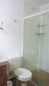 y baño con aseo y ducha acristalada. en Apartamento no bairro de Mariscal a 300 metros praia do Canto Grande, en Bombinhas