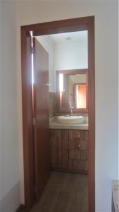 y baño con lavabo y espejo. en Apartamento no bairro de Mariscal a 300 metros praia do Canto Grande, en Bombinhas