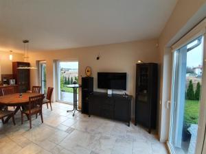 a living room with a table and a television and a dining room at Jurates Villa in Palanga