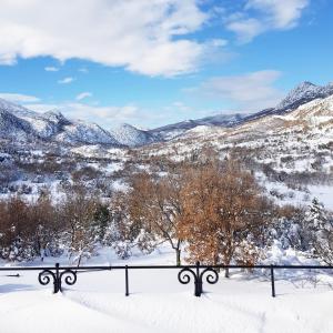 a snow covered valley with mountains in the distance at Helicon Muses Friendly Mountain B&B Guesthouse in Evangelístria +135 photos