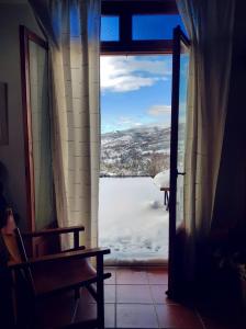 a window with a view of a snow covered yard at Helicon Muses Friendly Mountain B&B Guesthouse in Evangelístria