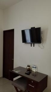 a flat screen tv hanging on a wall above a table at Hotel Parga in Aguascalientes