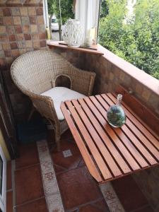 un banco, una mesa y un jarrón en un porche en Apartamento Árbol de vida - cerca Estadio Cartuja en Sevilla