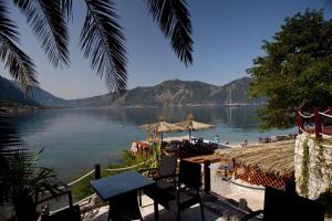 uma vista para um lago com uma mesa e cadeiras em Экономичная студия с тенистым патио вблизи пляжа em Kotor