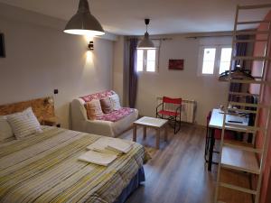 a bedroom with a bed and a couch and a chair at Mirador Madrid in Madrid