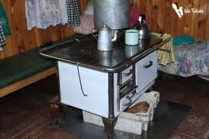 estufa antigua en una habitación con mesa en Hospedaje Isla Talcan en Dalcahue