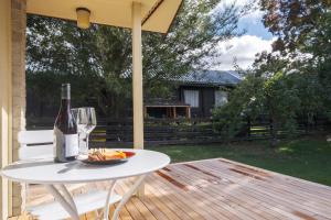 a bottle of wine and a plate of food on a table at Rees on Reid - Arrowtown Holiday Home in Arrowtown