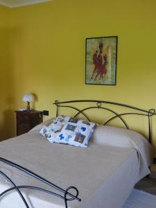 a bed in a room with a yellow wall at La Bella Dormiente B&B in Castellamonte