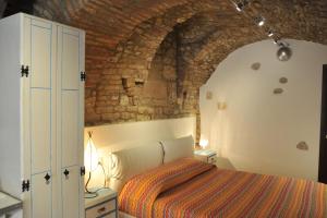 a bedroom with a bed and a brick wall at Vico Del Poeta in Assisi