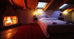 a bedroom with a large bed and a fireplace at Mansion Viglatoras in Ano Poroia