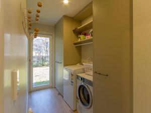 a laundry room with a washing machine and a window at Alchemy Cottage - Arrowtown Holiday Home in Arrowtown