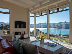 a living room with a couch and a table at Kotare Point Paradise - Akaroa Holiday Home in Akaroa