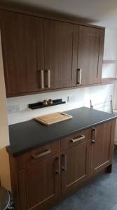 a kitchen with a counter top and wooden cabinets at Beautiful king room in Leith Walk in Edinburgh