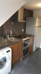 a kitchen with a sink and a washing machine at Beautiful king room in Leith Walk in Edinburgh