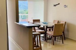 - une salle à manger avec une table et des chaises dans l'établissement Apto Completo C/Ar, Varanda Gourmet e Piscina, à Ubatuba