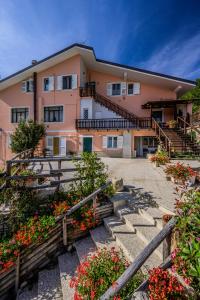 un edificio con escaleras y flores delante en B&B Apartments Casa Sullavalle, en Montefortino