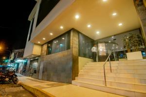 a man standing on the stairs of a building at night at El Dorado Classic Hotel in Iquitos