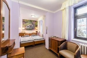a small room with a bed and a window at Hotel Perla Jizery in Josefŭv Dŭl
