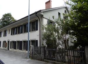 ein altes weißes Gebäude mit einem Zaun davor in der Unterkunft Chambres d'hôtes T'22 in Fleurier