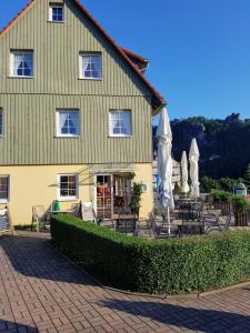 a building with chairs and umbrellas in front of it at Eisenbahnwelten in Kurort Rathen