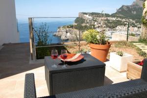 una mesa con 2 copas de vino en el balcón en Villa Blau de Lluna, en Puerto de Sóller