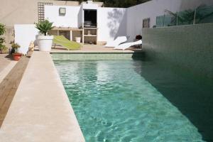 a swimming pool with green water next to a building at Villa Blau de Lluna in Port de Soller