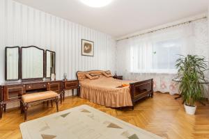 een slaapkamer met een bed, een bureau en een spiegel bij 3 room central apartmend 90m2 parking for one car fifth floor and the building does not have an elevator in Tallinn