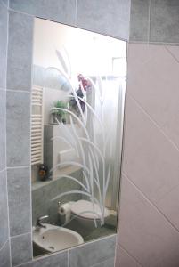 La salle de bains est pourvue d'un miroir, de toilettes et d'un lavabo. dans l'établissement Bed and Breakfast Il Girasole, à Lamporecchio