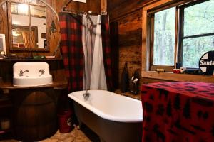 Country Woods Inn في غلين روز: حمام مع حوض استحمام ومغسلة