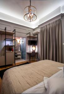 a bedroom with a large bed and a chandelier at Esperia Boutique Hotel in Agrinio