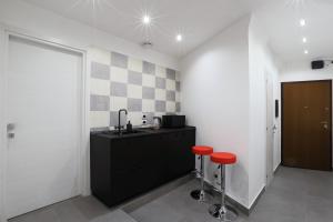 a kitchen with a sink and two red stools at Napoli Vesuvio Apartments by Dimorra in Naples