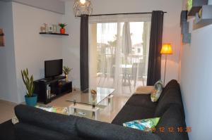 een woonkamer met een bank en een glazen tafel bij Luxury Apartment in Paphos City