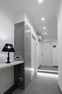 a lamp on a table in a room with a walk in shower at Napoli Vesuvio Apartments by Dimorra in Naples