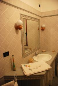 y baño con lavabo y espejo. en Bed and Breakfast Il Girasole, en Lamporecchio