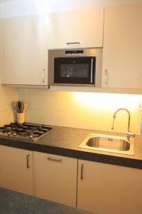 a kitchen with a sink and a microwave at Appartement Sincfala in Knokke-Heist