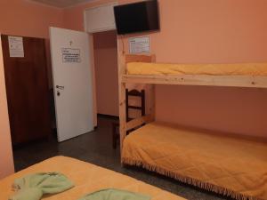 a room with two bunk beds and a flat screen tv at Hotel El Nevado, Malargüe Mendoza in Malargüe